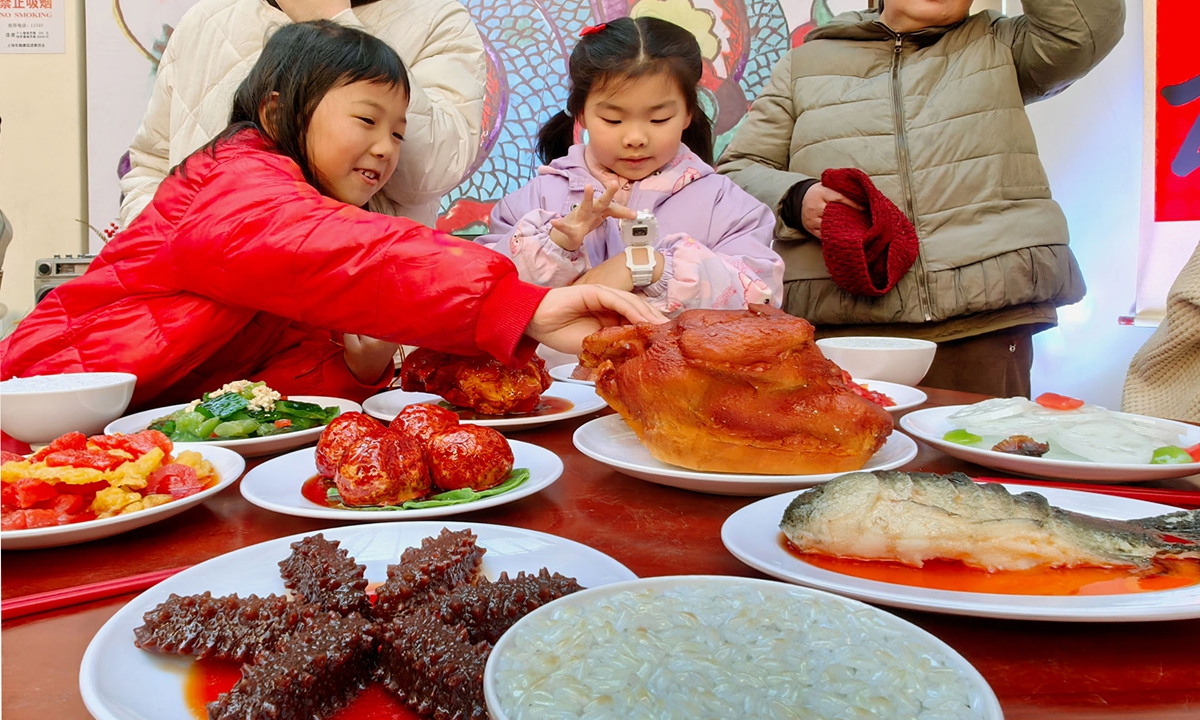 Children sample Shanghai-style Chinese New Year food at an exhibition, on January 28, 2024. 