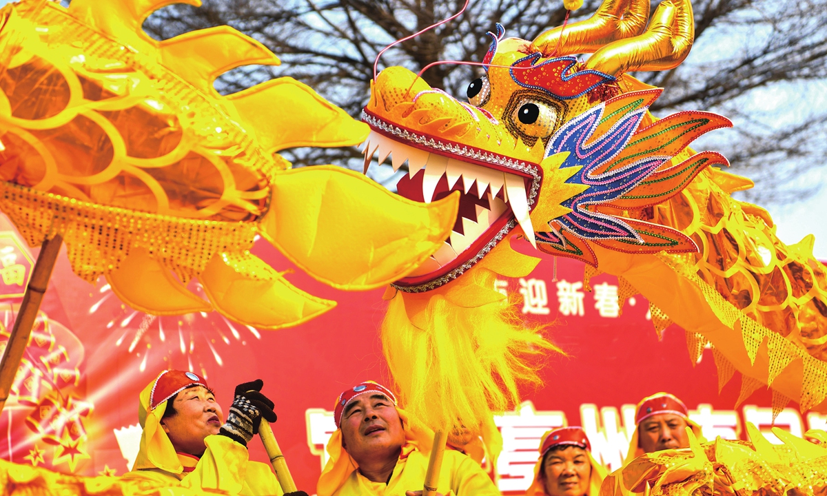 People perform a dragon dance during Spring Festival. In a Chinese dragon dance, the dragon's head biting its tail implies good luck. Photo: VCG