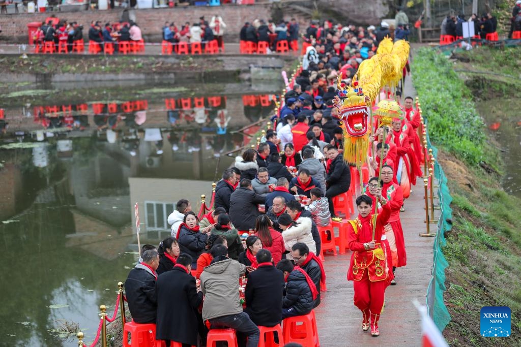 Villagers have meals while watching a dragon dance performance in Peishi Town of Nanxi District in Yibin City, southwest China's Sichuan Province, Feb. 5, 2024.(Photo: Xinhua)