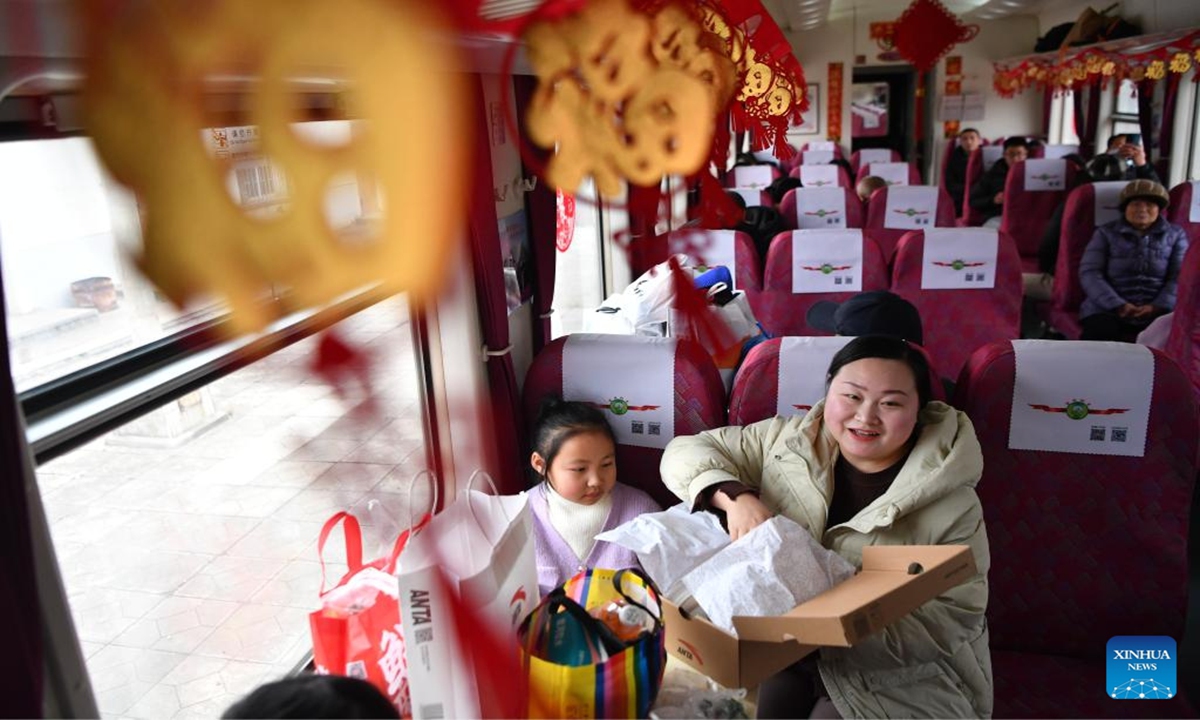 This photo taken on Feb. 4, 2024 shows passengers on their way home after shopping aboard the train No. 7503 in northwest China's Gansu Province. The pair of slow trains No. 7503 and No. 7504 run between Tianshui and Longxi in Gansu. Local residents are now taking them to travel between their towns and the urban areas to shop for goods in preparation of the upcoming Chinese Lunar New Year, or the Spring Festival.(Photo: Xinhua)