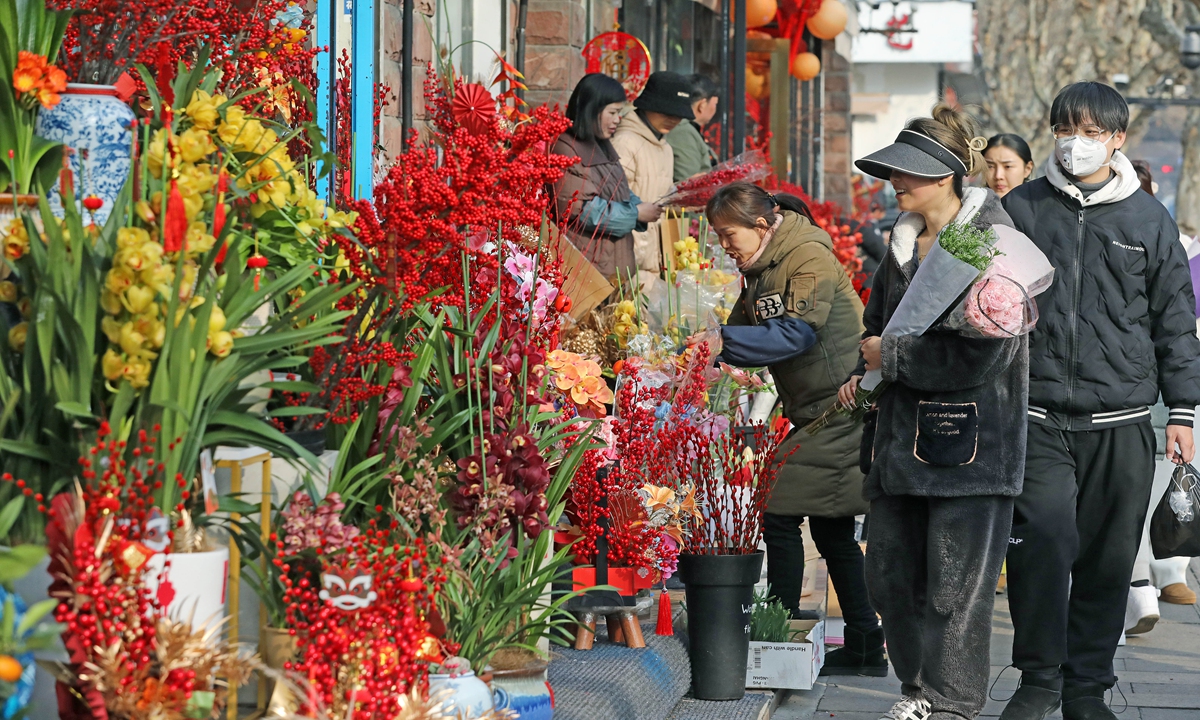 Residents in Hangzhou, capital of East China's Zhejiang Province, buy flowers and green plants on February 8, 2024. Demands for flowers as well other decorations that add to the festive mood, have jumped in recent days, ahead of the Spring Festival holidays which fall on Saturday. Photo: VCG