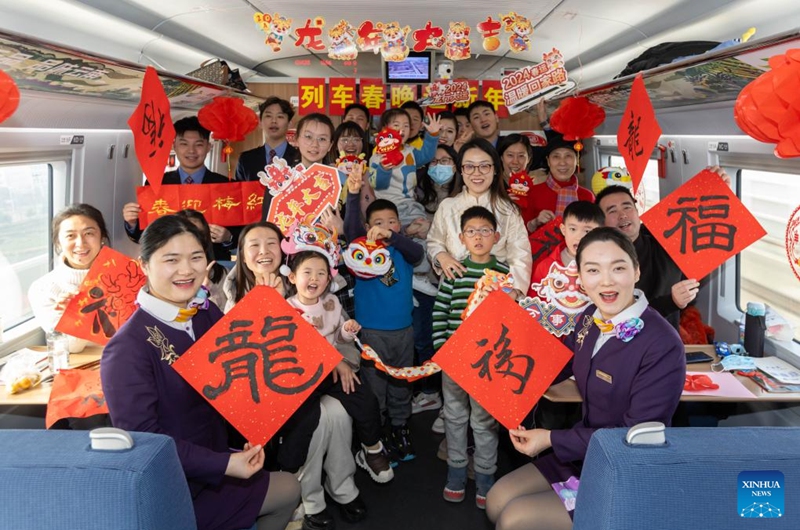 Staff members and passengers pose for photos during a Spring Festival celebration event on the train G1426, Feb. 9, 2024. People across the country held various celebrations on Friday, the Chinese Lunar New Year's eve, to welcome the traditional festival. Photo: Xinhua
