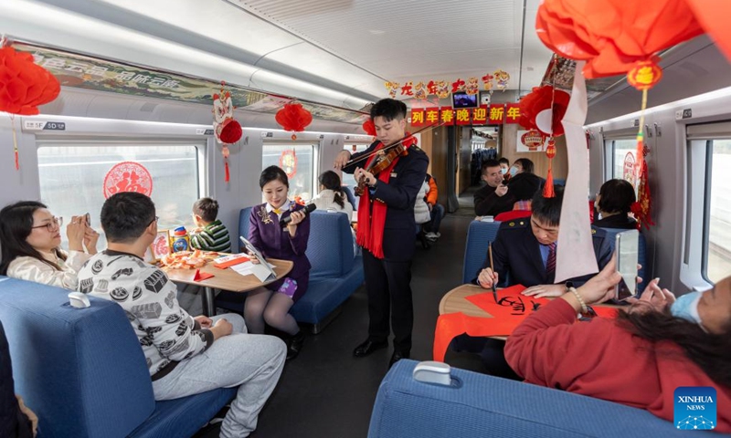A staff member plays the violin for passengers during a Spring Festival celebration event on the train G1426, Feb. 9, 2024. People across the country held various celebrations on Friday, the Chinese Lunar New Year's eve, to welcome the traditional festival. Photo: Xinhua