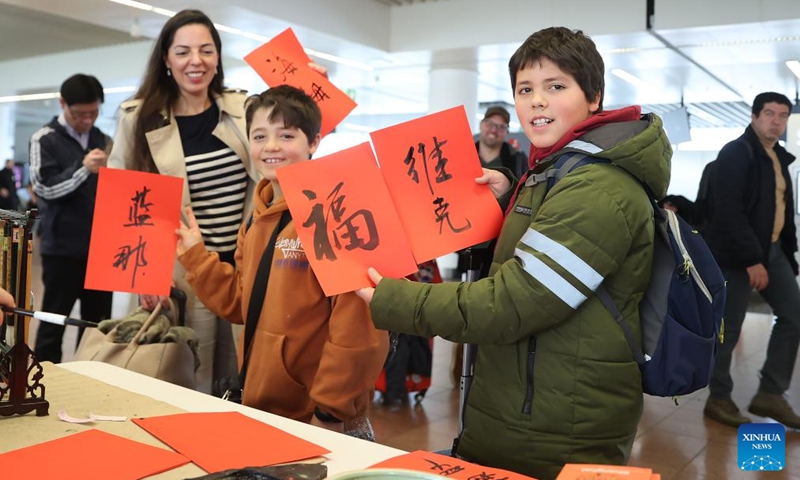 Tourists demonstrate calligraphy works of Chinese character Fu, which means good fortune, and their names at the Brussels Airport in Zaventem, Belgium, Feb. 9, 2024. The festive atmosphere to welcome the Chinese Lunar New Year fills the air at the Brussels Airport with various celebration activities held here. Photo: Xinhua