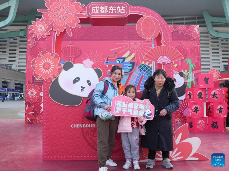 Passengers pose for photos with a Spring Festival decorative installation at Chengdu East Railway Station in Chengdu, southwest China's Sichuan Province, Feb. 9, 2024. People across the country held various celebrations on Friday, the Chinese Lunar New Year's eve, to welcome the traditional festival. Photo: Xinhua