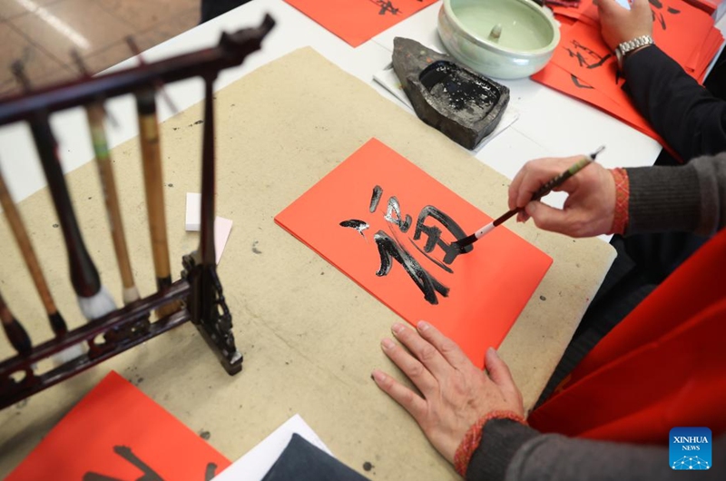 A calligrapher writes Chinese character Fu, which means good fortune, at the Brussels Airport in Zaventem, Belgium, Feb. 9, 2024. The festive atmosphere to welcome the Chinese Lunar New Year fills the air at the Brussels Airport with various celebration activities held here. Photo: Xinhua