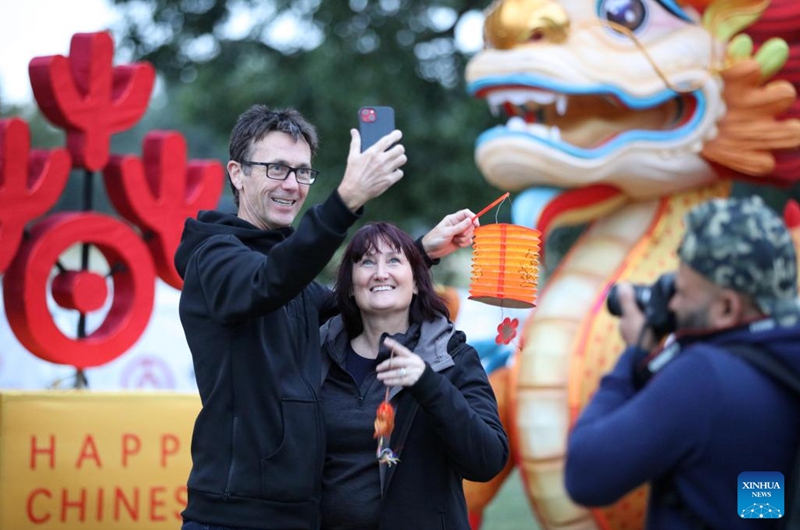 Tourists take selfies in front of a dragon-shaped installation to welcome the Chinese Lunar New Year at Hagley Park in Christchurch, New Zealand, Feb. 9, 2024. Photo: Xinhua
