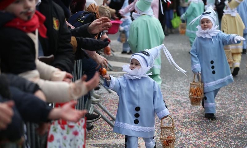 Children give oranges symbolizing good luck to visitors during the parade of Shrove Tuesday, the last day of Carnival, in Binche, Belgium, Feb. 13, 2024. Binche's three-day carnival, a UNESCO World Heritage event and one of the most famous carnivals in Europe, reached its climax on Tuesday. (Photo: Xinhua)