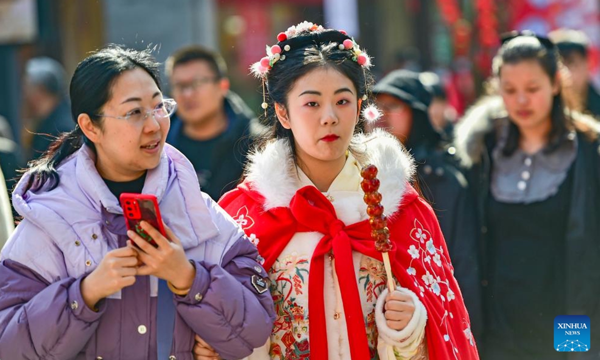 A tourist in traditional costume visits a scenic spot in Qingzhou City, east China's Shandong Province, Feb. 12, 2024. Many people choose to wear traditional Chinese costumes to celebrate the Chinese New Year. (Photo by Wang Jilin/Xinhua)
