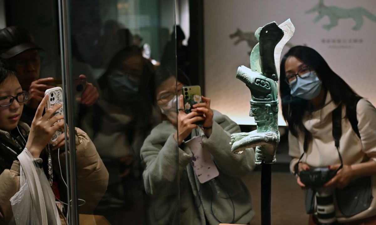 Visitors take photos of an exhibit during the exhibition of Stars over China: The Ancient Shu Civilization of Sanxingdui and Jinsha in Shanghai Museum, Shanghai, east China, Feb. 15, 2024. (Xinhua/Liu Ying)