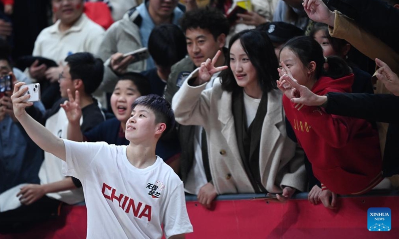 Basketball enthusiasts pose for photos with Chinese basketball player Li Yuan (L, front) after a match in Xi'an, northwest China's Shaanxi Province, Feb. 11, 2024. In addition to following traditional customs, more and more Chinese people choose to enrich their life by spending the Spring Festival holiday in diversified and original ways. (Photo: Xinhua)