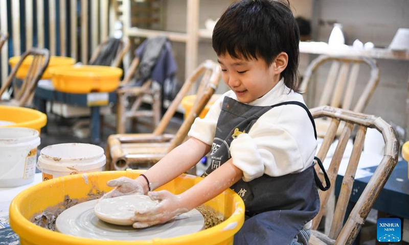 A child tries to make pottery wares at the Beicang Cultural and Creative Block in southwest China's Chongqing Municipality, Feb. 15, 2024. In addition to following traditional customs, more and more Chinese People choose to enrich their life by spending the Spring Festival holiday in diversified and original ways. (Photo: Xinhua)