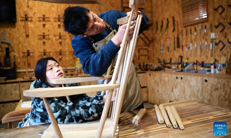 Young couple Guo Zhengzhang (R) and Jiao Dongyan make a rocking chair at a woodworking workshop in Liaocheng, east China's Shandong Province, on Feb. 16, 2024. They learned woodworking skills during this Spring Festival holiday and tried to jointly make a rocking chair. In addition to following traditional customs, more and more Chinese people choose to enrich their life by spending the Spring Festival holiday in diversified and original ways. (Photo: Xinhua)