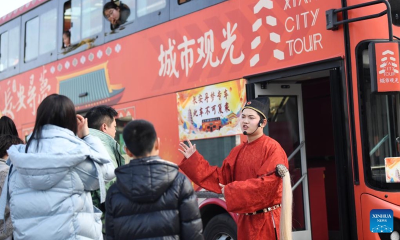 Tourists interacts with a staff member who acts as a historical figure while taking a sightseeing bus for a city tour in Xi'an, northwest China's Shaanxi Province, Feb. 15, 2024. In addition to following traditional customs, more and more Chinese People choose to enrich their life by spending the Spring Festival holiday in diversified and original ways. (Photo: Xinhua)