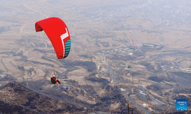 A person paraglides in Yuanshi County of Shijiazhuang City, north China's Hebei Province, Feb. 14, 2024. In addition to following traditional customs, more and more Chinese people choose to enrich their life by spending the Spring Festival holiday in diversified and original ways.  (Photo: Xinhua)