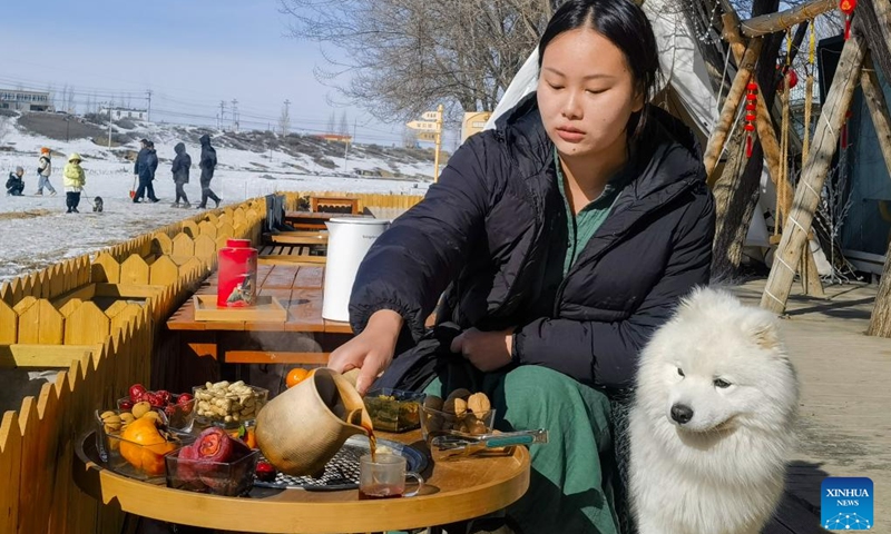 A tourist makes tea at a camp site in Urumqi County, northwest China's Xinjiang Uygur Autonomous Region, Feb. 14, 2024. In addition to following traditional customs, more and more Chinese People choose to enrich their life by spending the Spring Festival holiday in diversified and original ways. (Photo: Xinhua)