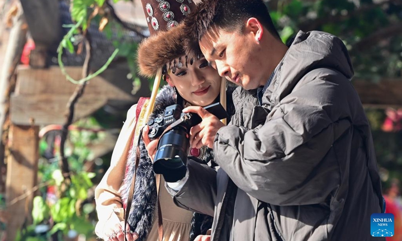 Tourists take photos at the Xinjiang International Grand Bazaar in Urumqi, northwest China's Xinjiang Uygur Autonomous Region, Feb. 15, 2024. In addition to following traditional customs, more and more Chinese People choose to enrich their life by spending the Spring Festival holiday in diversified and original ways. (Photo: Xinhua)