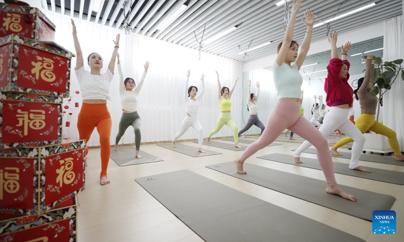 People practice yoga at a yoga club in Tancheng County of Linyi, east China's Shandong Province, on Feb. 16, 2024. In addition to following traditional customs, more and more Chinese people choose to enrich their life by spending the Spring Festival holiday in diversified and original ways. (Photo: Xinhua)