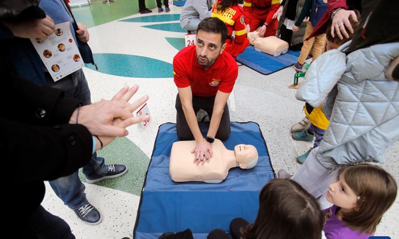Paramedics (in red) explain resuscitation maneuvers on medical mannequins during the 3rd edition of Resuscitation Marathon in a mall in Bucharest, Romania, March 2, 2024. (Photo by Cristian Cristel/Xinhua)