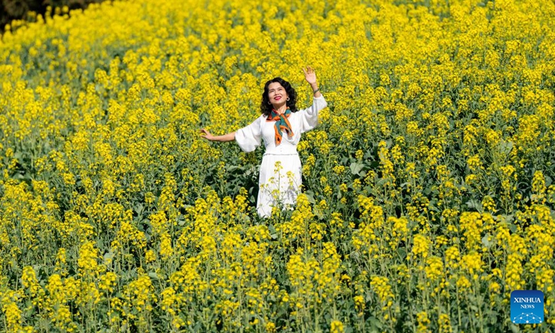 A woman poses for photos in the cole flower fields in Luoping County, southwest China's Yunnan Province, Feb. 19, 2024. (Xinhua/Hu Chao)