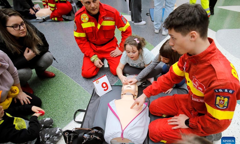 Paramedics (in red) explain resuscitation maneuvers on medical mannequins during the 3rd edition of Resuscitation Marathon in a mall in Bucharest, Romania, March 2, 2024. (Photo by Cristian Cristel/Xinhua)
