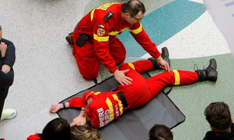 A paramedic explains medical check on one of his colleagues during the 3rd edition of Resuscitation Marathon in a mall in Bucharest, Romania, March 2, 2024. (Photo by Cristian Cristel/Xinhua)

