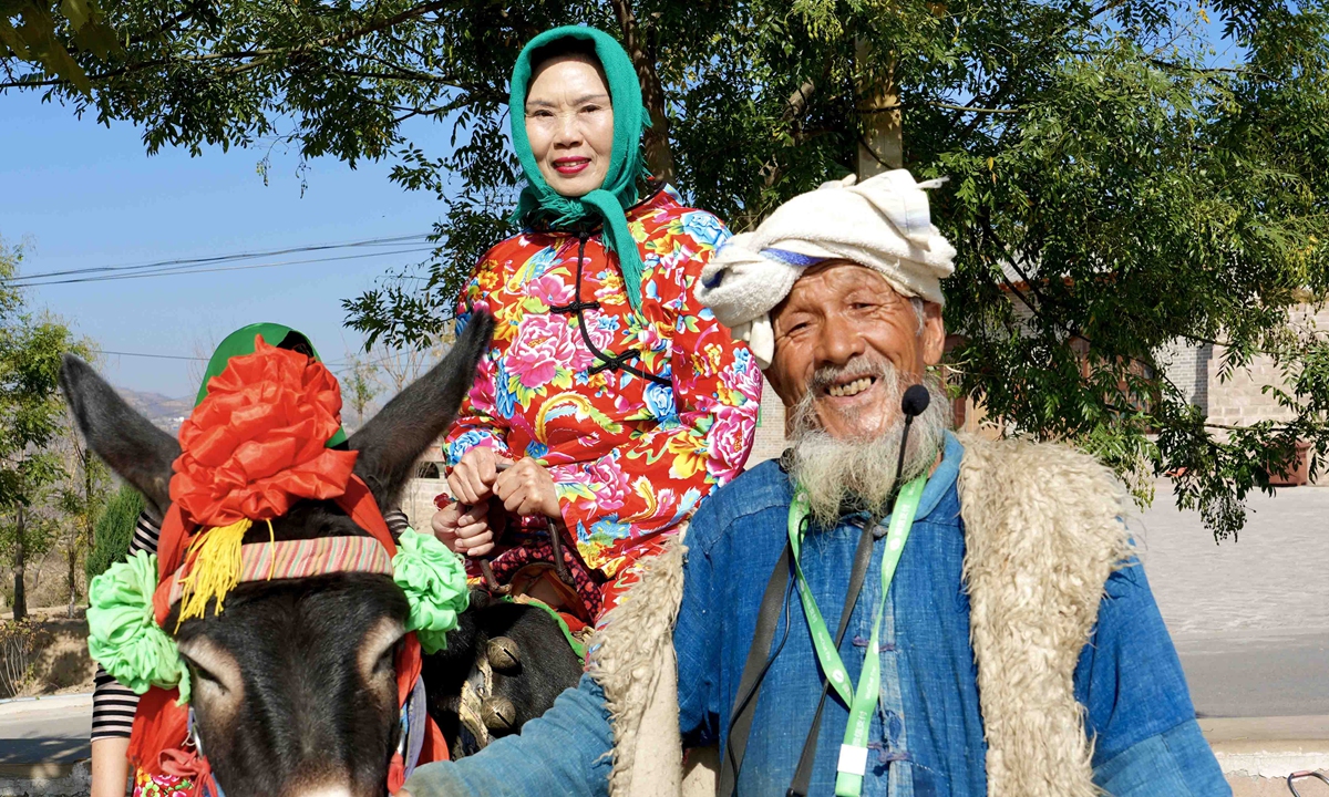 A villager in Qikou ancient town in North China's Shanxi leads his donkey carrying visitors through the town. Photo: Courtesy of Lu Pengyu