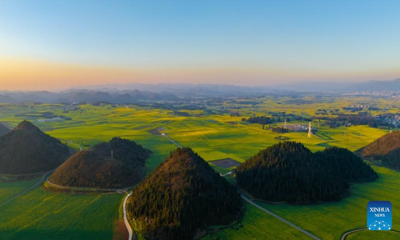 A drone photo taken on Feb. 19, 2024 shows sunrise above the cole flower fields in Luoping County, southwest China's Yunnan Province. (Xinhua/Hu Chao)