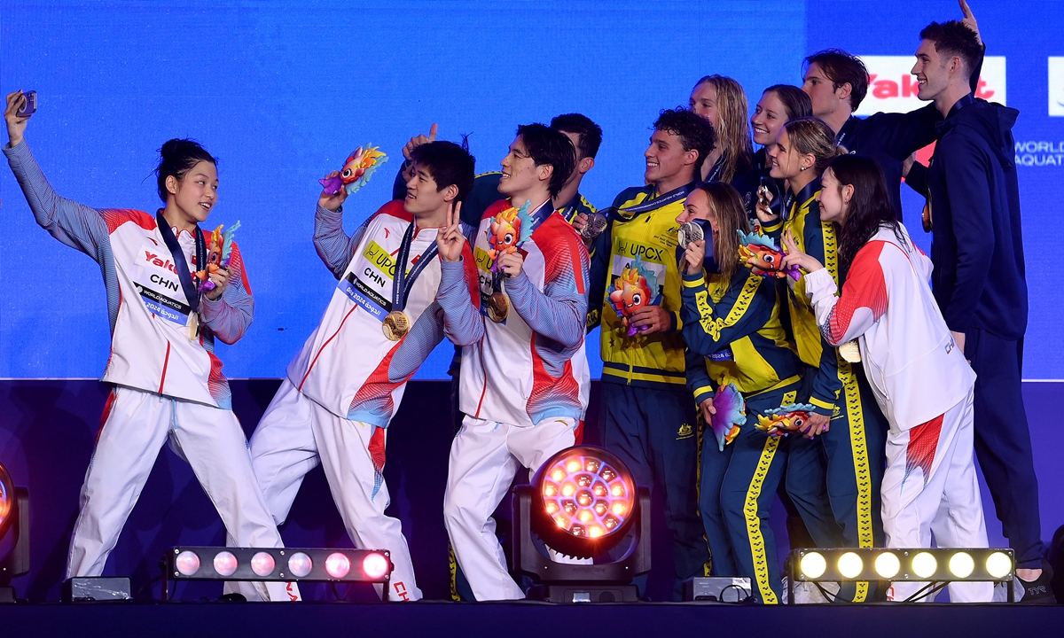 Chinese swimmers pose for a group photo with silver medalists Team Australia and bronze medalists Team USA after winning gold in the mixed 4x100-meter freestyle final of the Doha 2024 World Aquatics Championships on February 17, 2024 in Doha, Qatar. Team China won gold with a new Asian record time of 3 minutes and 21.18 seconds. Photo: VCG