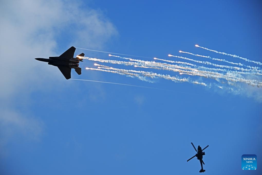 A F-15SG fighter jet and an AH-64D Apache attack helicopter of Singapore Air Force perform during the media preview of Singapore Airshow in Singapore, Feb. 18, 2024.(Photo: Xinhua)