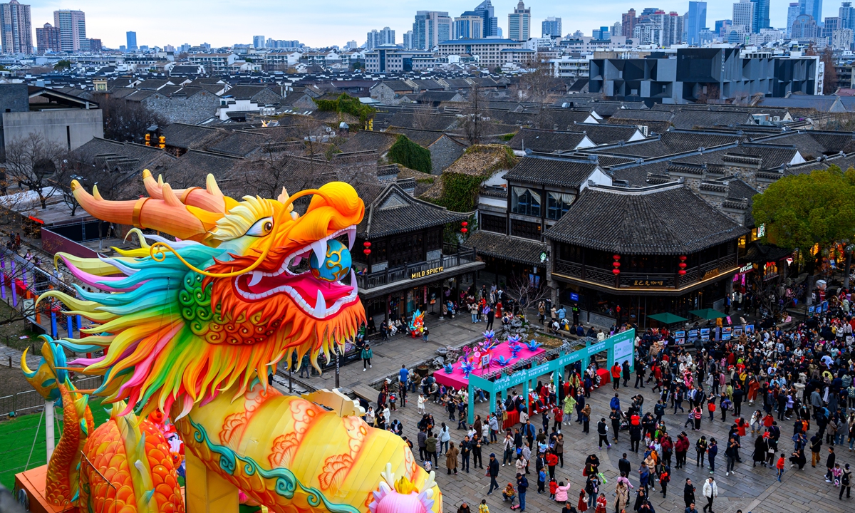 People flood to visit a 14-meter high dragon lantern displayed at the Zhonghua Gate in Nanjing, East China's Jiangsu Province, on February 17, 2024. Photo: VCG 