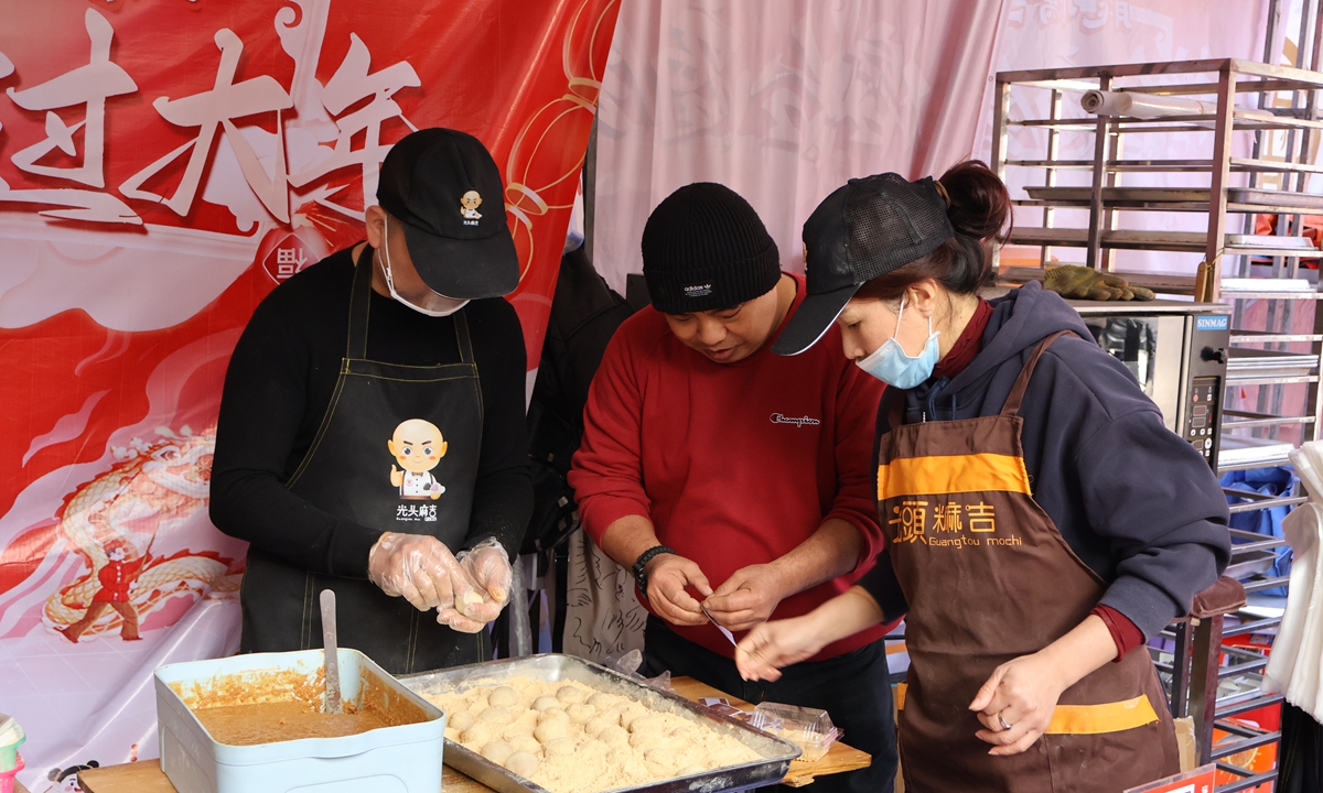Lin Fa-wei (center) and his wife Wei Jinyan (right), wrap mochi at the cross-Straits New Year goods exhibition at the historic Shangxiahang traditional block in Fuzhou, on February 11, 2024. Photo: Lin Xiaoyi/GT