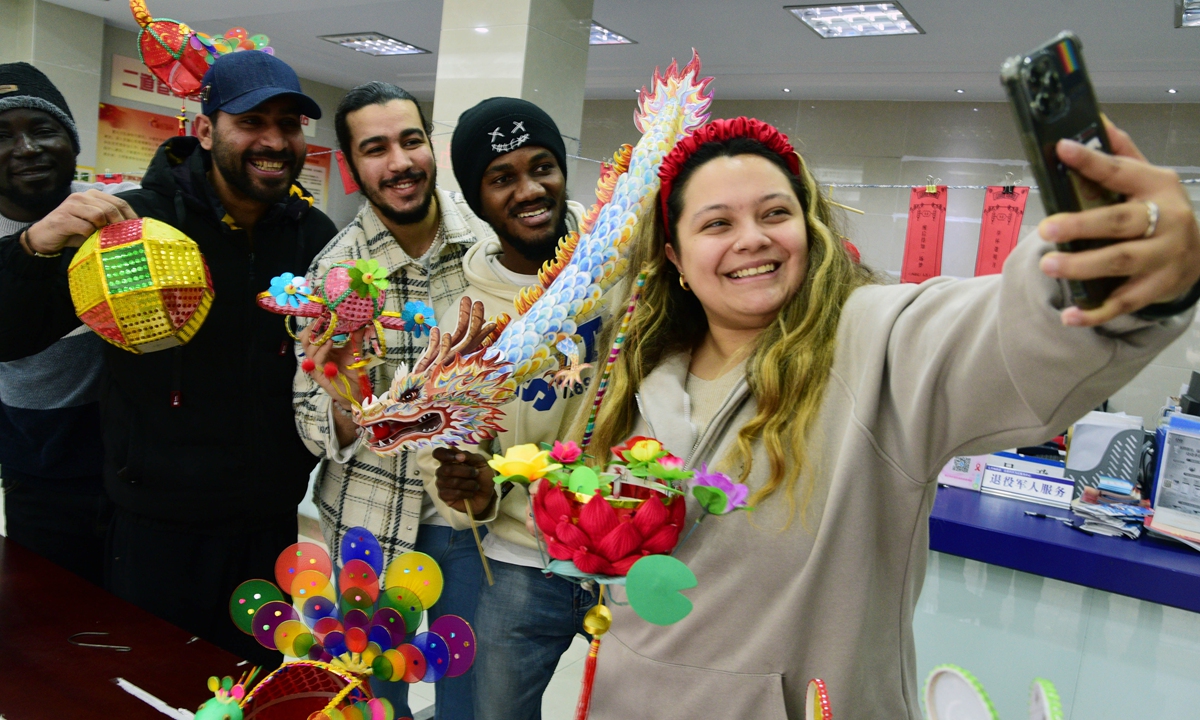 Foreign students take a selfie with the lanterns they just made in Zhenjiang, East China's Jiangsu Province on February 20, 2024. Photo: VCG