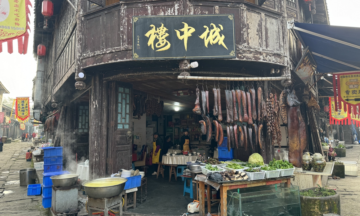 Cured pork belly and fresh vegetables are displayed outside a resturant  in Chongqing's Laitan Ancient Town. Photo: Li Yuche/GT