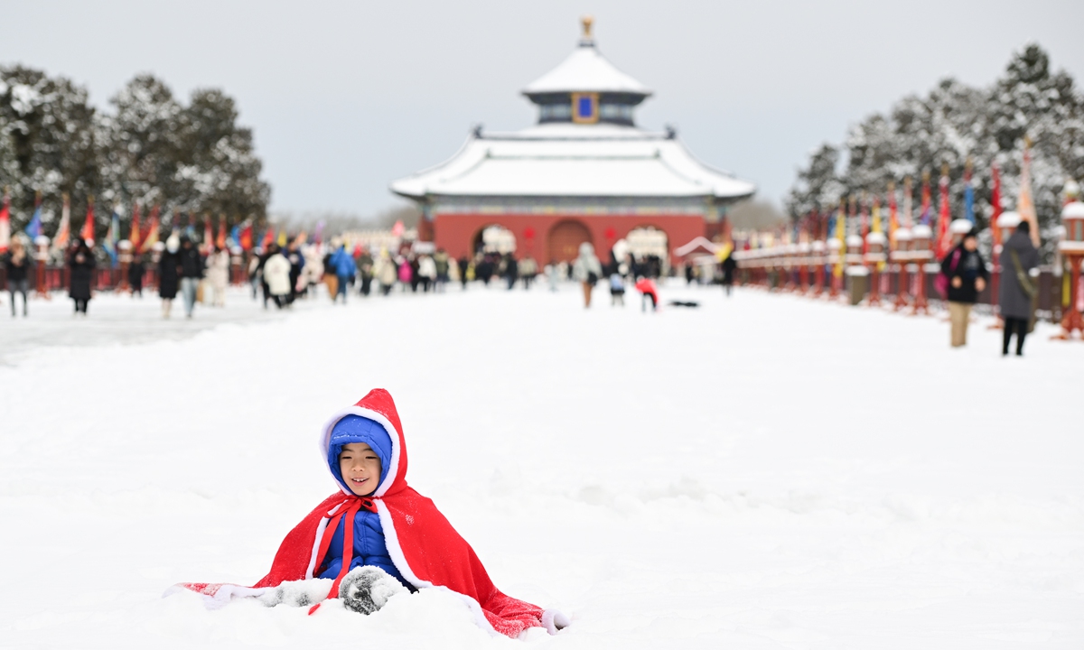 A child plays in the snow at the Tiantan (Temple of Heaven) Park in Beijing, capital of China on February 21, 2024. After a spring snowfall, the park was covered with a blanket of snow, attracting many visitors. Photo: VCG