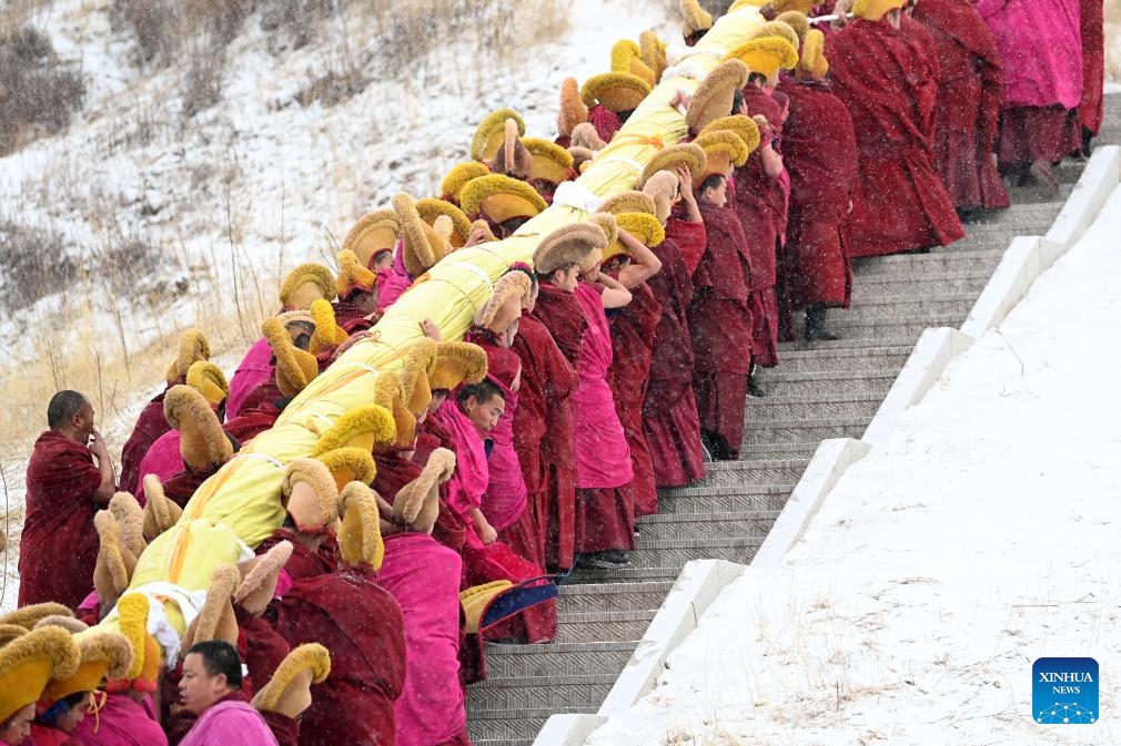 Monks carry a huge Thangka painting bearing the image of the Buddha during the annual sunning of the Buddha ceremony of Labrang Monastery in Xiahe County, northwest China's Gansu Province, Feb. 22, 2024.(Photo: Xinhua)