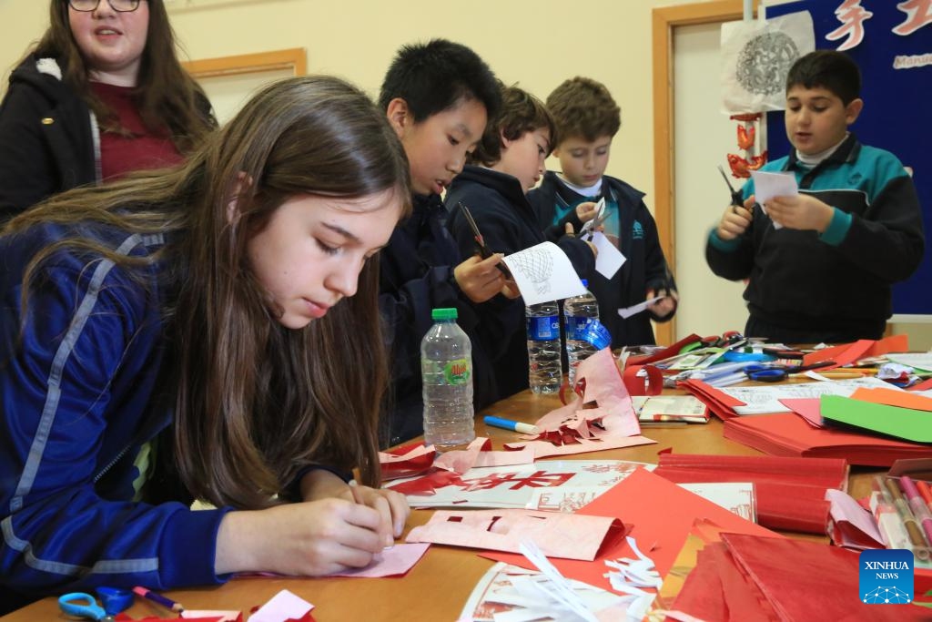 Students make Chinese paper-cuts at a school in Pembroke, Malta, on Feb. 22, 2024. On Thursday, an event for the Chinese Lantern Festival was held at St. Clare Pembroke Secondary School, northeastern Malta, featuring singing and dancing, Chinese paper-cuts, tasting of dumplings, and trying on traditional Chinese clothing known as Hanfu.(Photo: Xinhua)
