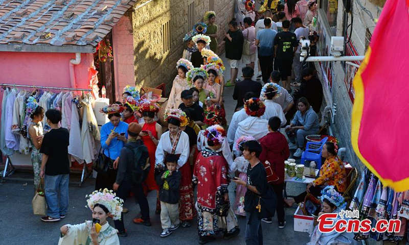 Visitors wearing flowery headwear are seen at Xunpu Village of Quanzhou, east China's Fujian Province, Feb. 21, 2024. (Photo: China News Service)
