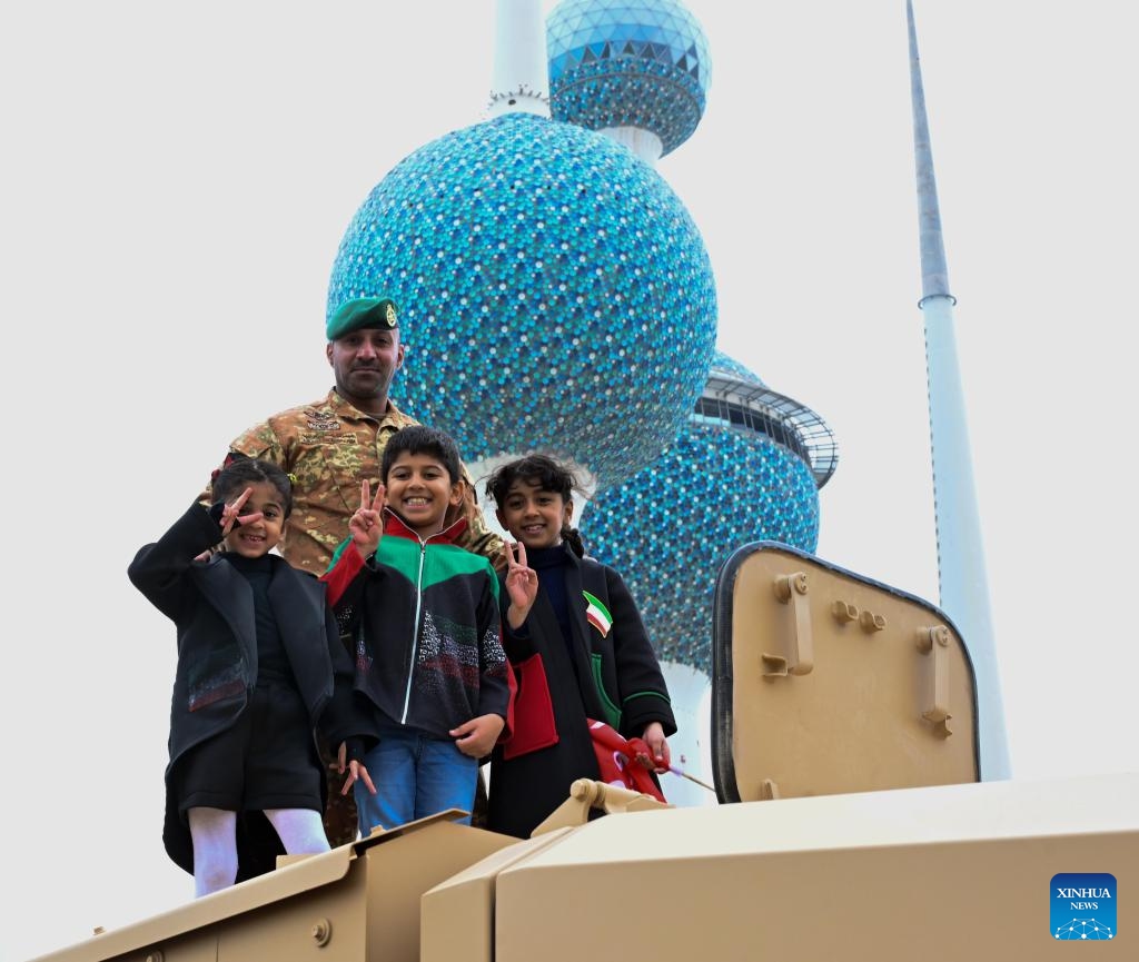 Kids take photos with a soldier in an army parade during the celebration in Capital Governorate, Kuwait, Feb. 25, 2024. Kuwaitis celebrate their national and liberation days on Feb. 25 and 26 every year.(Photo: Xinhua)