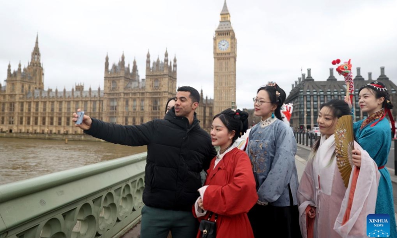 A man takes selfies with Hanfu enthusiasts in front of the Houses of Parliament in London, Britain, Feb. 25, 2024. Hanfu enthusiasts wearing Hanfu, a style of clothing traditionally worn by the Han people, introduced Chinese traditional culture to local people and visitors in London on Sunday.(Photo: Xinhua)