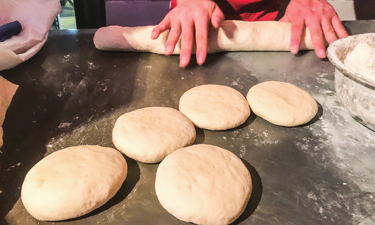 A cook makes <em>shaobing</em> in the morning. Photo: VCG