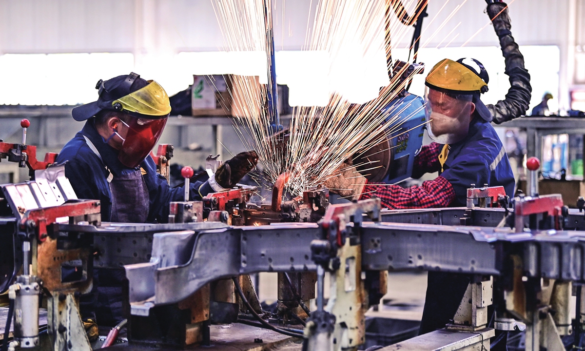 Intelligent robots on the production line operate rapidly, while human workers are busy assembling new-energy electric box-type cars for export in the workshop of a new-energy vehicle manufacturing company in the Economic Development Zone of Ganzhou, East China's Jiangxi Province, on February 18, 2024. Photo: VCG