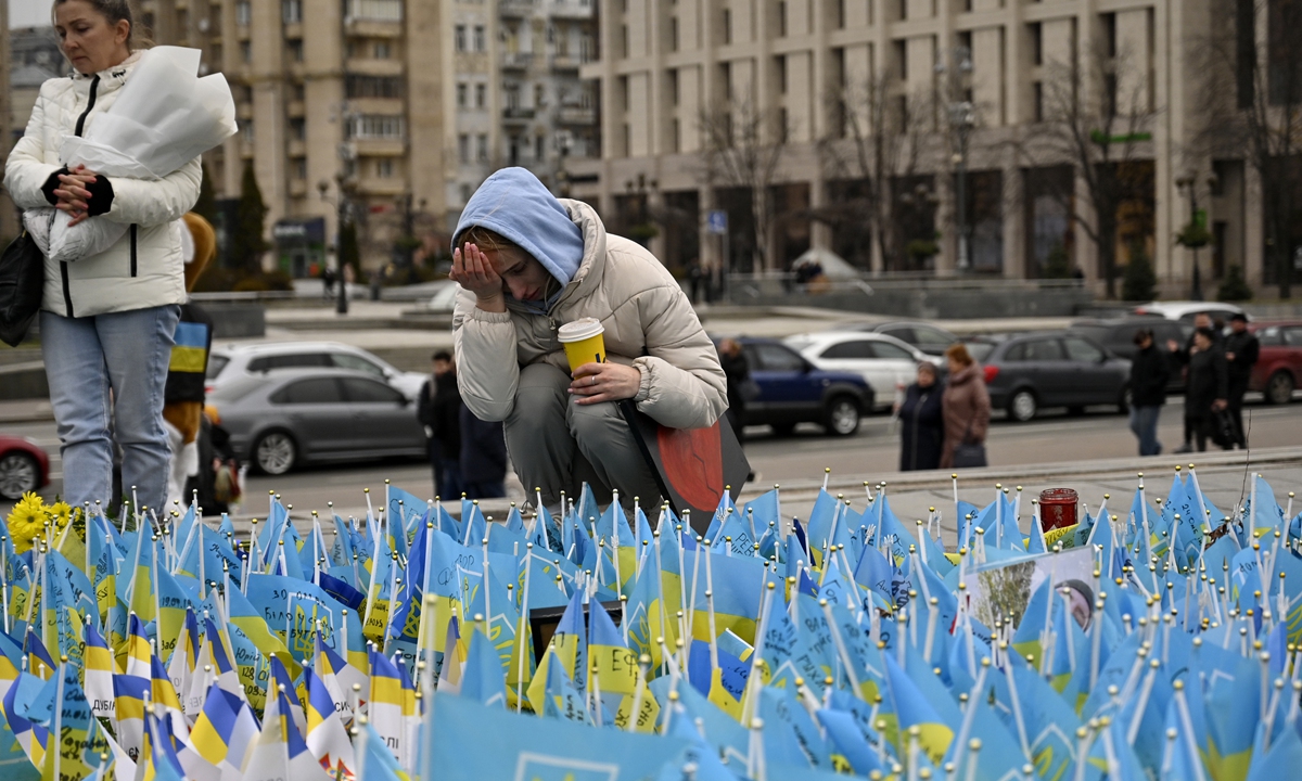  A woman wipes tears near Ukrainian flags with the names of the fallen Ukrainian soldiers who died during the Russia-Ukraine conflict at the Independence Square on February 24, 2024, the second anniversary of the conflict. Photo: VCG 