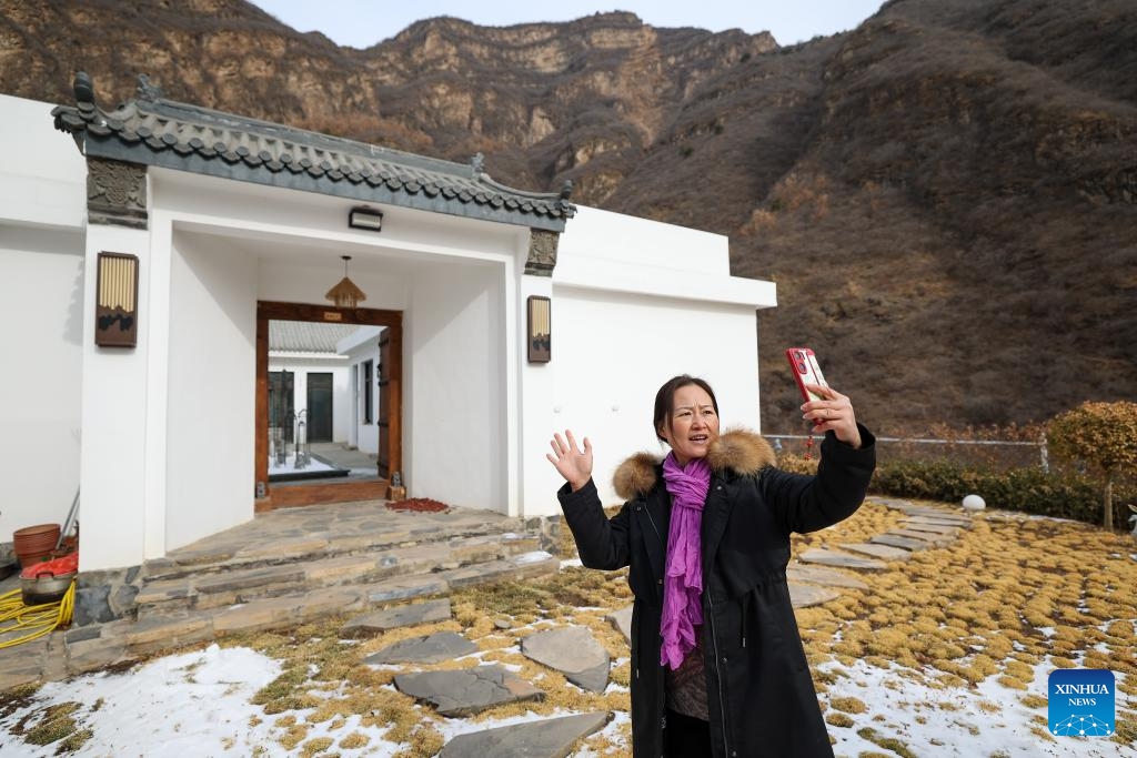 A homestay manager takes a short video to promote her business in Qian'ganjian Village, Xiaying Township, north China's Tianjin, Feb. 23, 2024. Before this year's Spring Festival, three villages including Qian'ganjian Village of Tianjin, Qian'ganjian Village of Hebei Province and Hongshimen Village of Beijing, all located at a border area between Tianjin, Hebei and Beijing, signed an agreement to jointly develop the tourism in the area and better protect the ancient Great Wall(Photo: Xinhua)