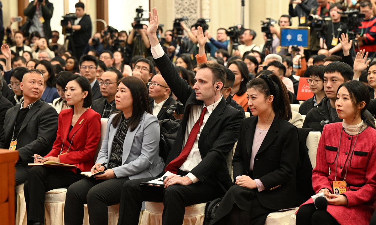 A foreign journalist raises his hand to ask a question at the news conference for the second session of the 14th CPPCC National Committee at the Great Hall of the People in Beijing on March 3, 2024. More than 3,000 reporters from home and abroad have registered to report on this year's two sessions, a significant increase compared to previous years. Photo: VCG