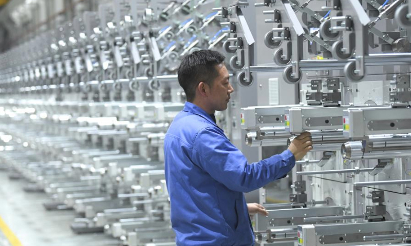 A technician makes adjustments on an in-house developed machine at a company in Keqiao District of Shaoxing, east China's Zhejiang Province, March 14, 2024. Keqiao District of Shaoxing is a cluster base for the textile industry, housing more than 8,000 textile businesses with an output value of over 100 billion yuan(about 13.9 billion U.S. dollars). In recent years, the district has promoted transformation and upgrading, introducing environmentally friendly machinery and innovative technologies. The local traditional industry, initially labor-intensive, is making a switch to a low-pollution, high-tech, and high-value advanced manufacturing segment. (Xinhua/Weng Xinyang)