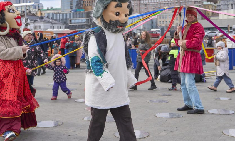 People participate in a circle dance in the central square in Vladivostok, Russia, March 17, 2024. On Sunday, the Russian Far East city of Vladivostok celebrates Maslenitsa, bidding winter farewell and welcoming spring. Locals engage in traditional games and enjoy blini in the central square. (Photo by Guo Feizhou/Xinhua)