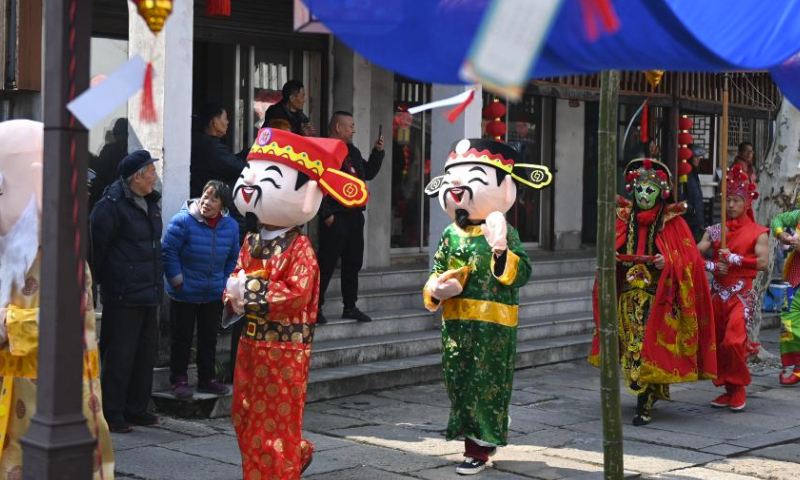 Folk culture performers wearing costumes are pictured during a parade at Shuanglin ancient town in Huzhou, east China's Zhejiang Province, March 9, 2024. A silk culture festival and temple fair parade was held here on Saturday and attracted many tourists. (Xinhua/Huang Zongzhi)