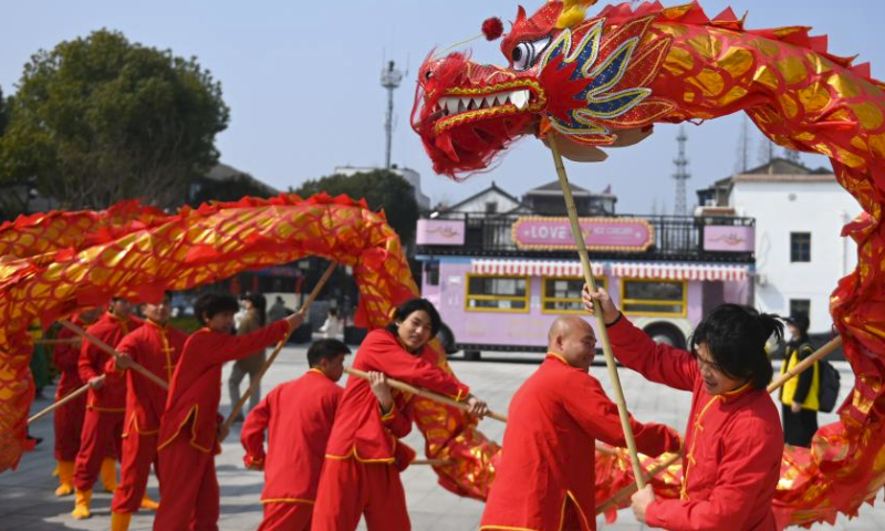 Folk artists perform dragon dance during a parade at Shuanglin ancient town in Huzhou, east China's Zhejiang Province, March 9, 2024. A silk culture festival and temple fair parade was held here on Saturday and attracted many tourists. (Xinhua/Huang Zongzhi)