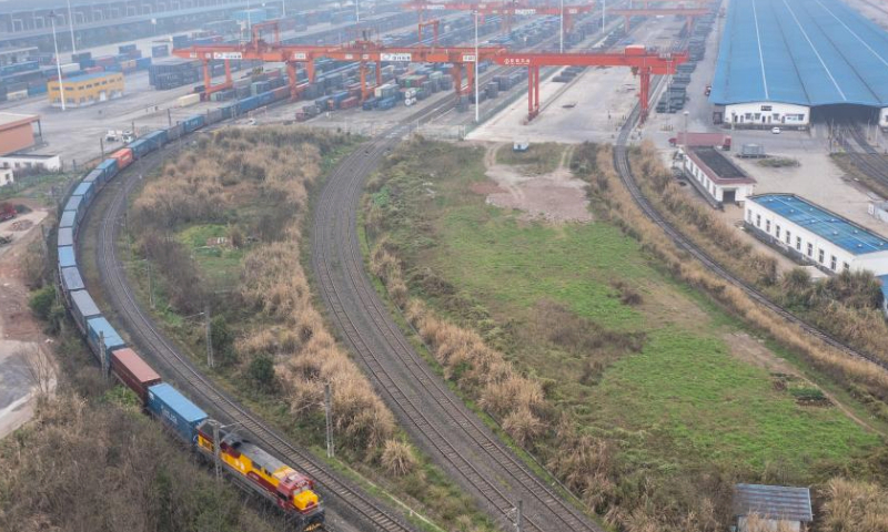 An aerial drone photo taken on March 7, 2024 shows a China-Europe freight train loaded with machinery, automobiles and auto parts pulling out of a railway station in Chongqing, southwest China. Benefiting from the increase of train trips and the launch of new freight train routes, including two direct rail routes to Spain and Türkiye, the city of Chongqing has seen increase in its export via China-Europe freight train service this year. Currently, the China-Europe freight train service has connected Chongqing with more than 100 cities and regions in Asia and Europe. Thousands of varieties of goods, including automobiles, auto parts, furniture, as well as medical equipment, have been transported via this service. (Xinhua/Huang Wei)